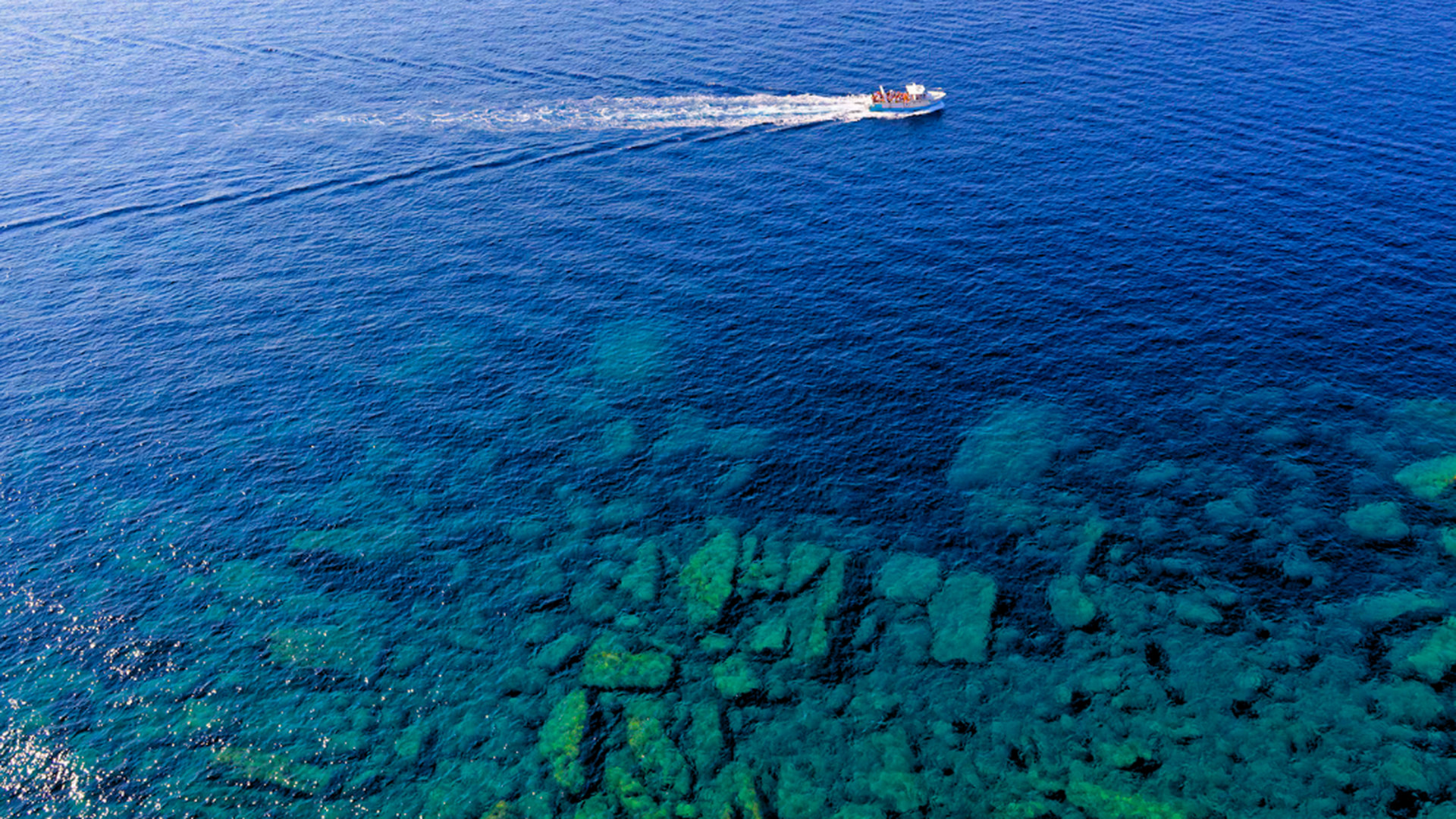 Lo stesso mare visto con lente polarizzata: colori pieni e scogli visibili sott'acqua